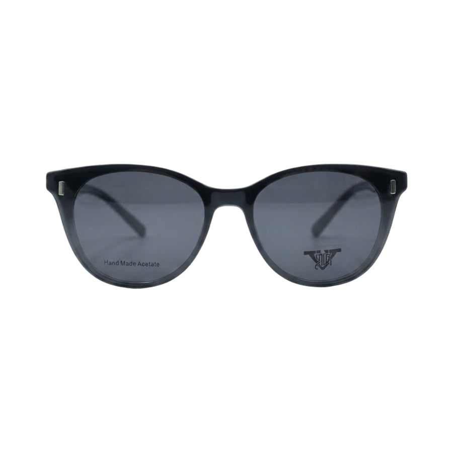 Green translucent acetate eyeglass frames with clear lenses and a pair of dark clip-on sunglasses placed in front, shown on a white background.
