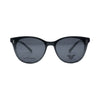 Green translucent acetate eyeglass frames with clear lenses and a pair of dark clip-on sunglasses placed in front, shown on a white background.